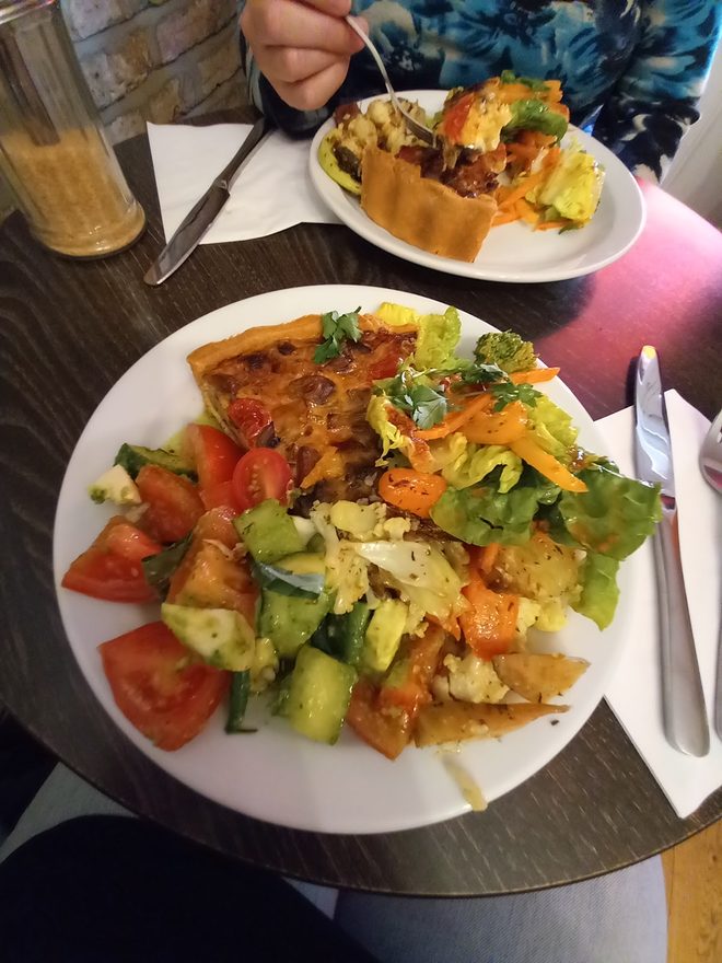 Scrambled eggs with tomato, avocado and salad on a dark table
