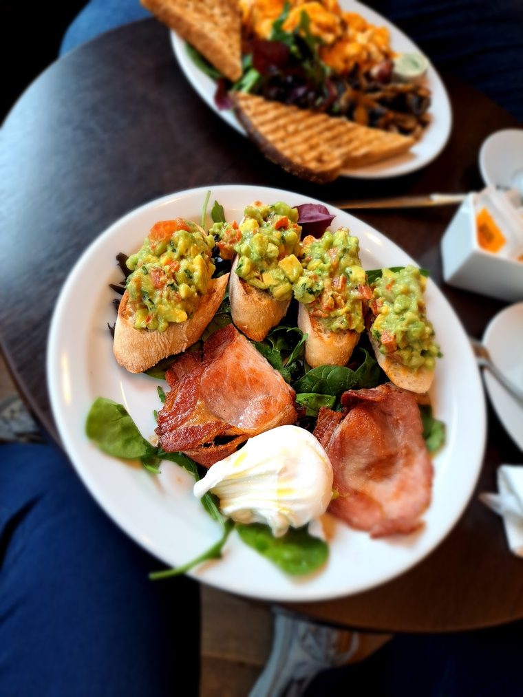 Avocado bruschetta with bacon and a poached egg