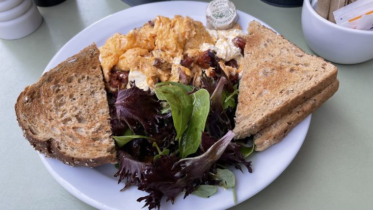 Scrambled eggs on toasted sourdough with dressed leaves