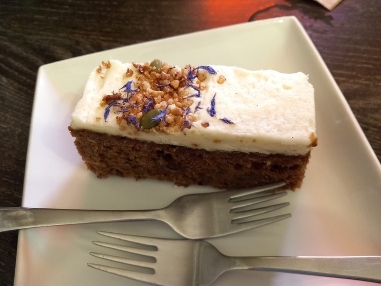 A slice of carrot cake with cream cheese frosting